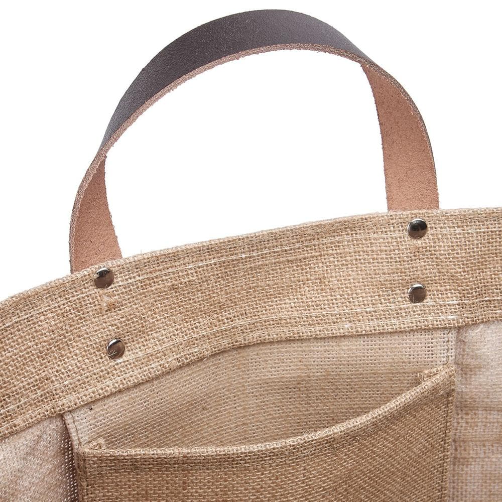 Close up picture of the Bazaar Tote from ShoreBags made from all-natural jute with natural canvas trim and leather handles. This bag has a laminated interior and is made from sustainable materials. 