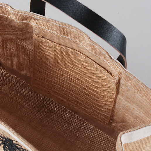 "Detail picture of Jute and leather small tote from ShoreBags featuring a laminated interior and a printed message Bees and Trees on the front side."